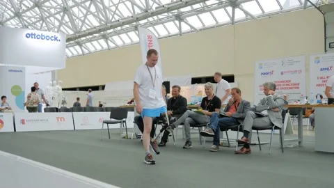 Disabled man with leg prosthesis walking in front of the jury at competition Stock Footage 152341868