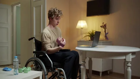 A disabled man is making hand exercises with special equipment Stock Footage 163181661