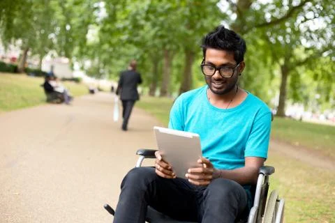Disabled man in the park with a tablet computer Stock Photos