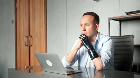 Disabled man programmer with bio hand prothesis at table Stock Footage 157533126