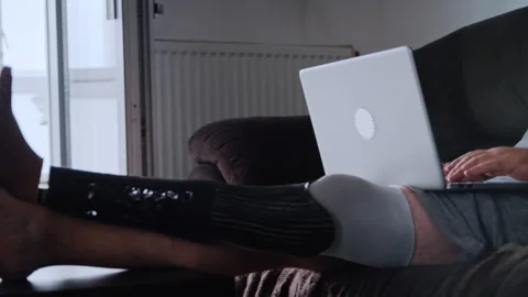 Disabled Man with Prosthetic Leg Working on Laptop at Home Video stock 317974280