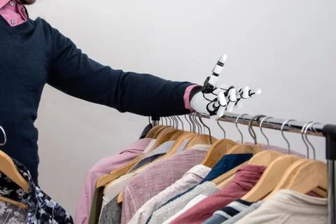 A disabled man with a robotic arm prosthesis chooses clothes Foto stock