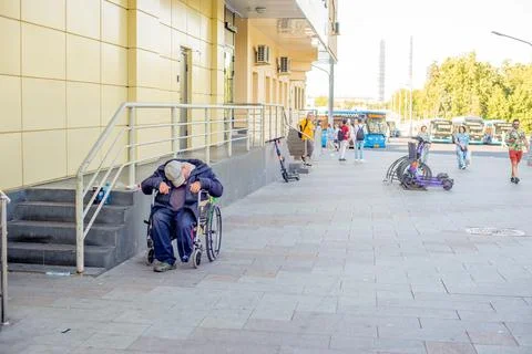 A disabled man sleeps in a wheelchair on the street24.07.2022 Russia,Moscow,  Stock Photos