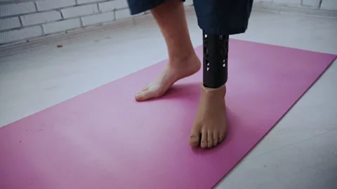Disabled Man Steps onto pink Yoga Mat for Exercise Routine Stock-Footage 317973045