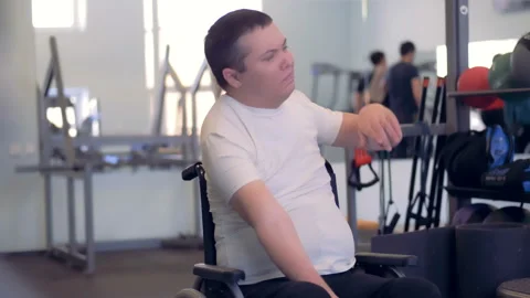 A disabled man is stretching his arms and shoulders while sitting in a 動画素材 87607058
