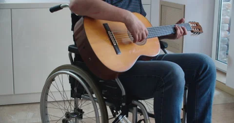 A disabled man is teaching how playing the guitar professionally at home Stock Footage 164393246