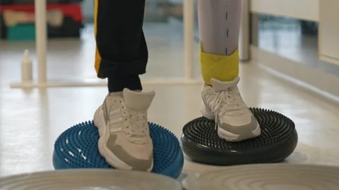 A disabled man with two leg prostheses overcomes obstacles, learns to walk on Stock Footage 264673740