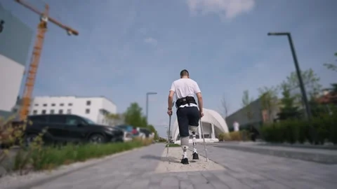 A disabled man with two leg prostheses overcomes obstacles, learns to walk on Stock Footage 276262647