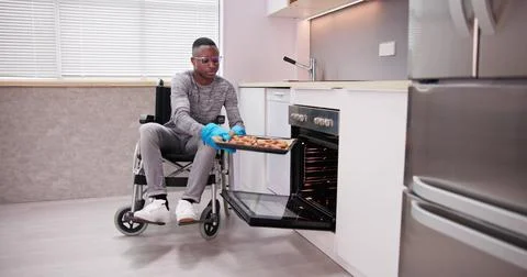 Disabled Man Using Microwave Oven For Baking Stock Photos