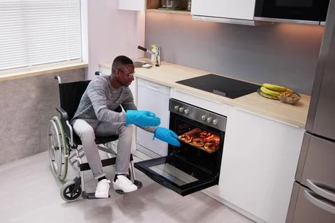 Disabled Man Using Microwave Oven For Baking Stock Photos