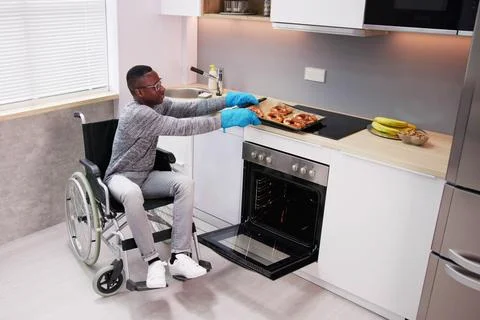 Disabled Man Using Microwave Oven For Baking Stock Photos