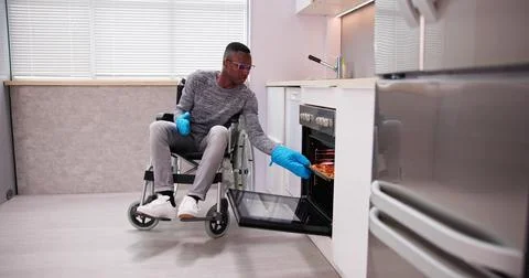 Disabled Man Using Microwave Oven For Baking Stock Photos