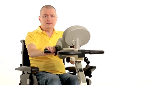 A disabled man in a wheelchair doing exercises for his hands and foots Stock Footage 233371908