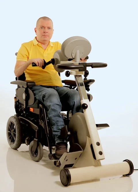A disabled man in a wheelchair doing exercises for his hands and foots Stock Footage 233371967