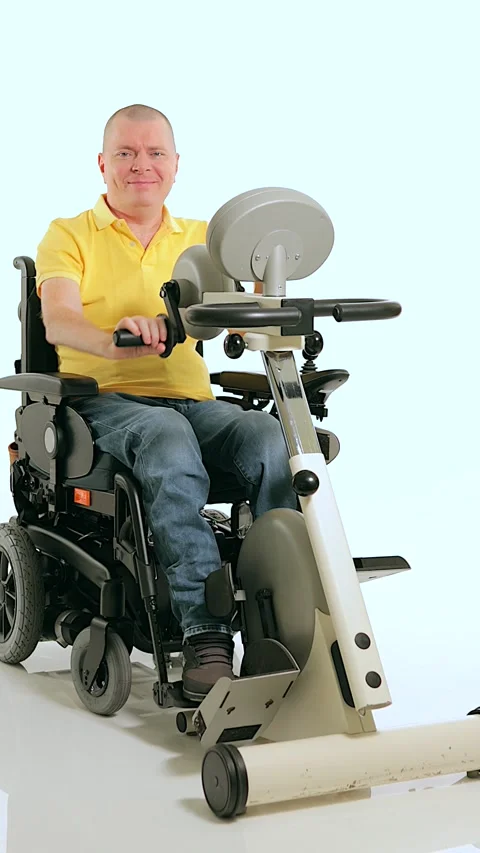 A disabled man in a wheelchair doing exercises for his hands and foots Stock Footage 233372012