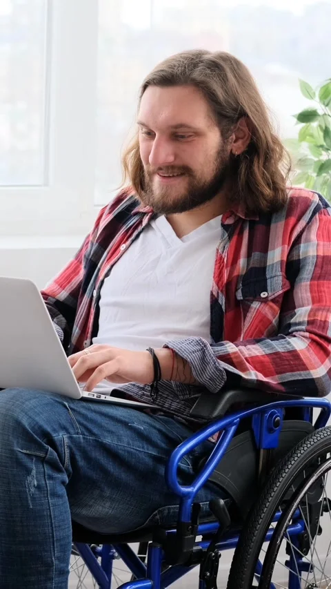 Disabled Man in Wheelchair Having a Video Call on Laptop Stock Footage 328122837