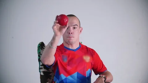 A disabled man in a wheelchair. Throwing a red little ball in the air. Boccia Stock Footage 98338041