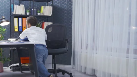 Disabled midget man trying to sit on chair in his office. Stock Footage 230978606