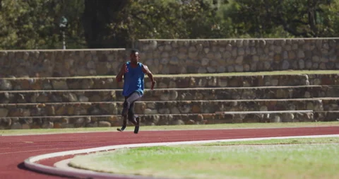 Disabled mixed race man with prosthetic legs running on race track Видео 130567353