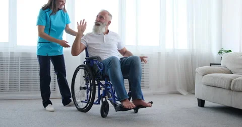 Disabled old man refusing female nurse for help and pushing self on wheelchair Stock Footage 141653332
