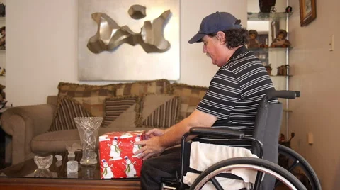 DISABLED-PARAPLEGIC AND PRESENT: old man with gift in wheelchair Stock Footage 45439945