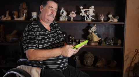 DISABLED-PARAPLEGIC: man with Ipad-tablet computer in wheelchair looks at camera Stock Footage 45438485
