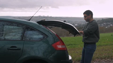 A disabled person closes the trunk of a car with his own hands. Stock Footage 268976082
