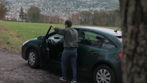 The disabled person opens the car door and gets into it. Stock Footage 268976135