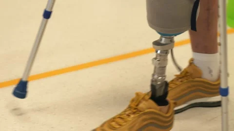 A disabled person with prostheses on two legs overcomes learning to walk with a Stock Footage 264672240