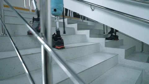 A disabled person with two prosthetic legs is undergoing rehabilitation. A Stock Footage 264672670