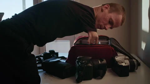 Disabled photographer with undeveloped hands preparing camera equipment Video stock 321942784