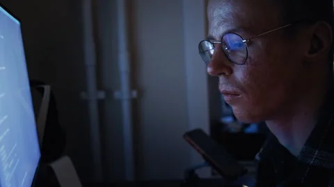 Disabled programmer with glasses coding at night Stock Footage 321937470