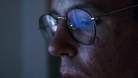 Disabled programmer with glasses coding at night Stock Footage 321937553