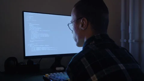 Disabled programmer with glasses working late night on computer 库存影片 321937322