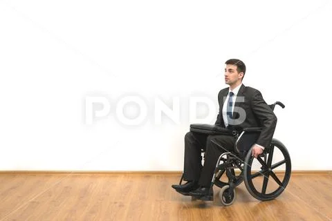 The disabled sitting in the wheelchair on the white wall background Stock Photos