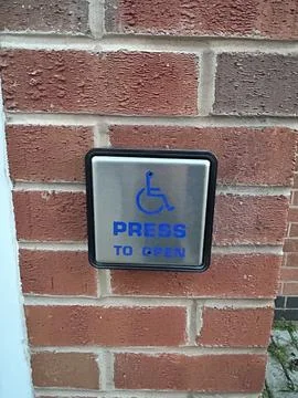 Disabled square door access button "Push to open" up close perspective Stock Photos