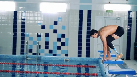 Disabled swimmer jumps into a training pool, side view. Stock Footage 99534729