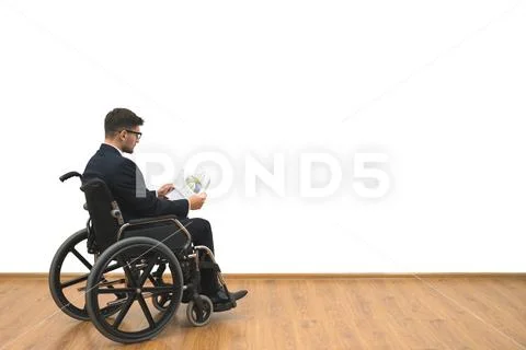 The disabled in a wheelchair holding papers on the white wall background Stock Photos