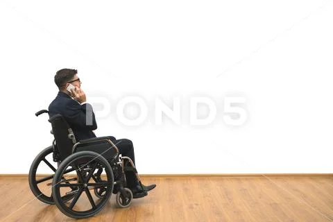 The disabled in a wheelchair phones on the white wall background Stock Photos