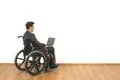 The disabled in a wheelchair works with a laptop on the white wall background Photo