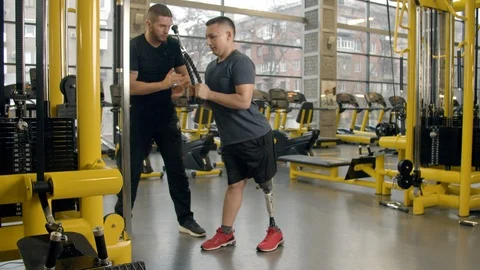 Disabled young man with instructor working out in gym Stock-Footage 125531171