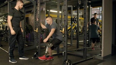 Disabled young man with instructor working out in gym Stock Footage 125532370