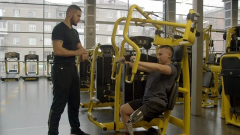 Disabled young man with instructor working out in gym Stock Footage 125533219