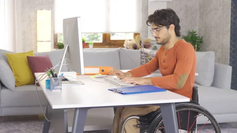 Disabled young man works with computer at home. Video stock 212888357