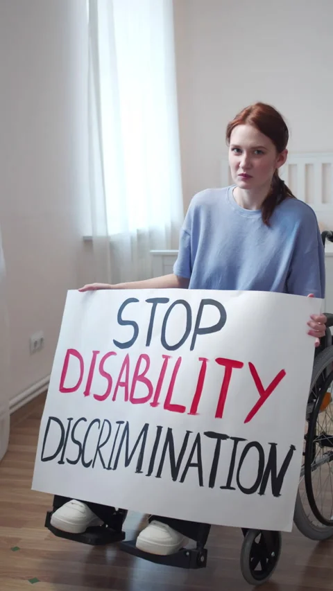 A disabled young woman is showing a poster and talking to the camera Stock Footage 163381663