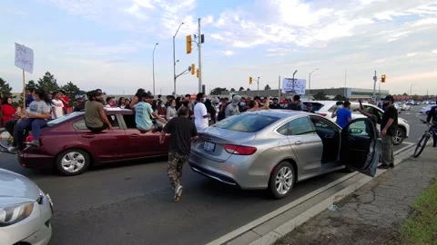Disagreement between angry demonstrators and driver caught in traffic Stock Footage 136854327