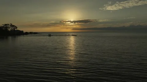 Disappearing sun behind clouds over Mobile Bay, Alabama aerial reverse Vidéo 233004294