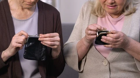 Disappointed aged women looking in empty purses, high utility rates, payment Stock Footage