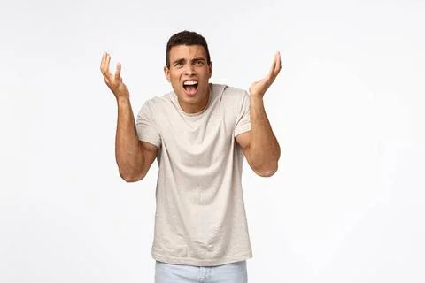 Disappointed and freak-out, bothered handsome man in t-shirt, raising hand... Stock Photos