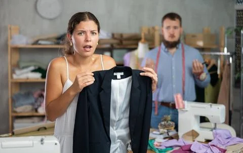 Disappointed customer reacting to defect in custom-made jacket Stock Photos